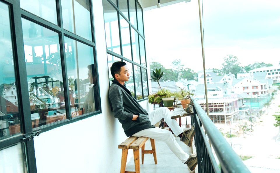 Man In Black Jacket Sitting On Bench Outdoors