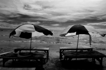 Grayscale Photography Of Two Picnic Tables On Seashore photo