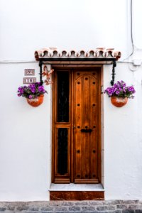 Brown Wooden Door Beside Two Purple Petaled Flowers