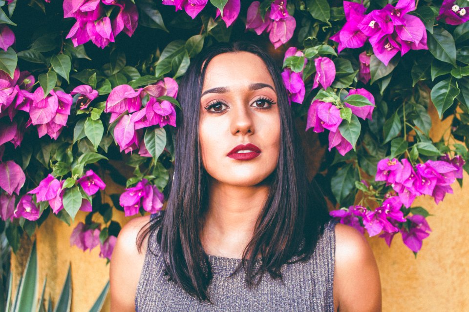 Woman In Gray Scoop-neck Sleeveless Top Standing In Front Of Purple Flowers