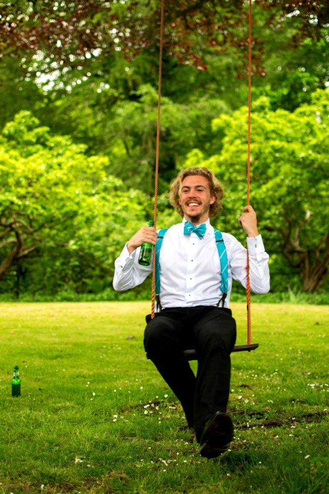 Man In White Dress Shirt And Black Pants Sitting On Swing photo