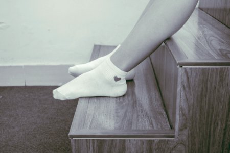 Person Wearing Pair Of Foot Socks Sitting On Staircase photo