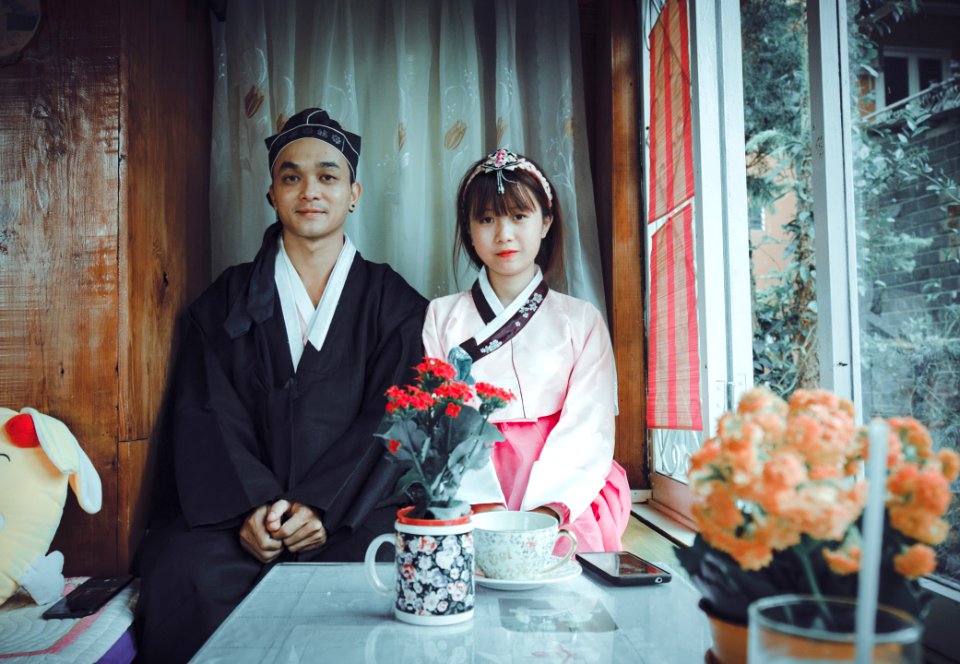 Man And Woman In Front Of Red Flowers photo