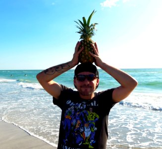Photography Of A Man Holding Pineapple photo