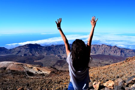Woman Standing On Mountain While Raising Her Hands photo