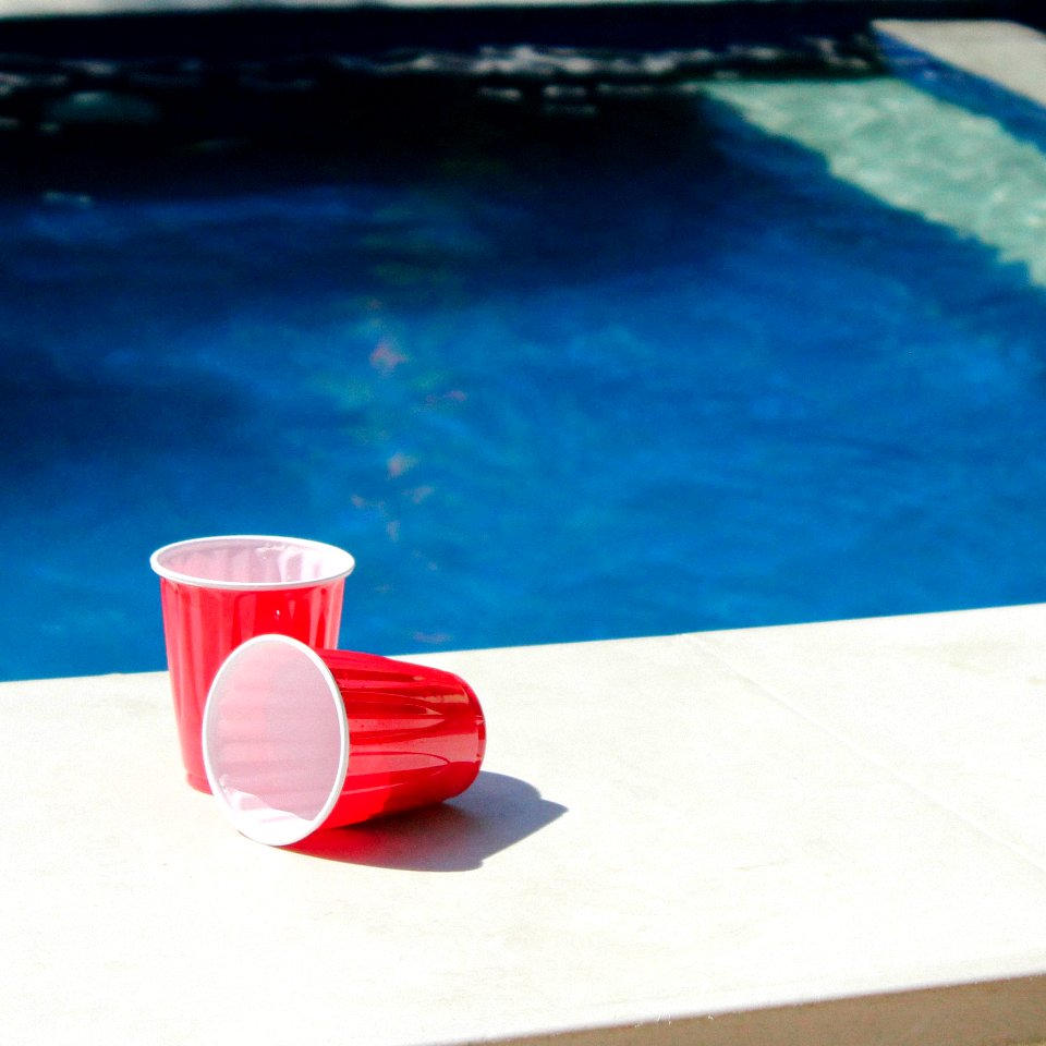 Two Red-and-white Disposable Cups On Gray Ceramic Tiles Photo
