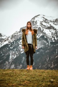 Woman Wearing Green Jacket In Front Of Snowy Mountain photo