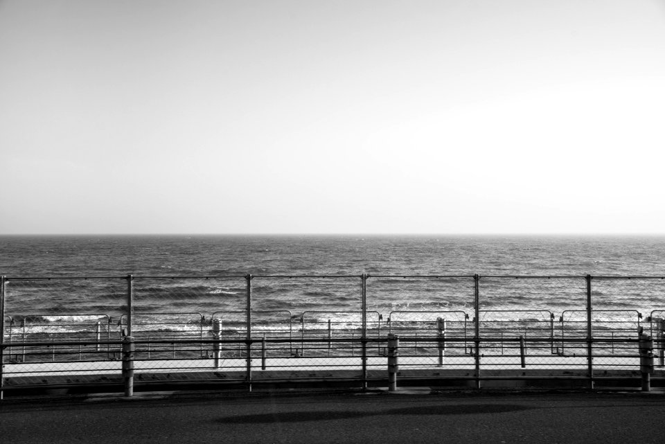 Grayscale Photography Of Fence Beside Ocean