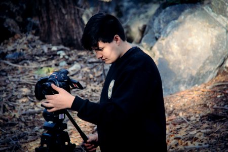 Man Holding And Looking At Dslr Camera On Camera Stand