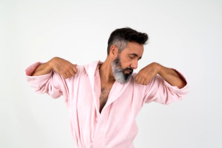 Man Wearing Pink Bathrobe With Both Hands On Shoulder