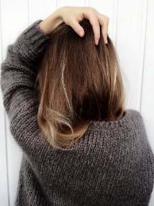 Woman Wearing Black Crew-neck Knitted Long-sleeved Shirt Beside White Wall