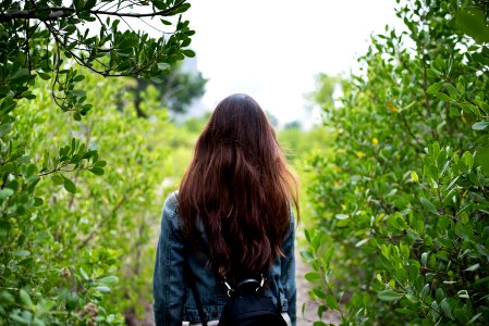 Woman In Gray Denim Jacket In The Middle Of Bushes