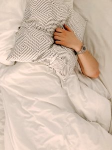 Person Holding Gray And White Throw Pillow photo