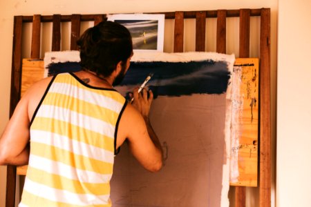 Man In White And Yellow Stripe Tank Top Painting On Canvas photo