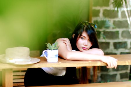 Woman Wearing White Shirt Sitting Near Table photo