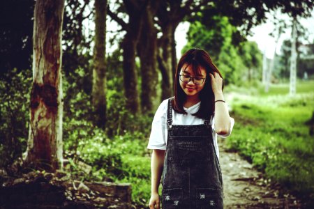 Woman Wearing White V-neck T-shirt And Black Denim Dungaree Standing Beside Trees photo