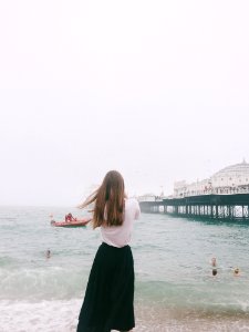 Woman Wearing White Shirt And Black Skirt Standing On Seashore photo