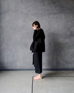 Woman In Black Gi Standing Beside Gray Wall photo
