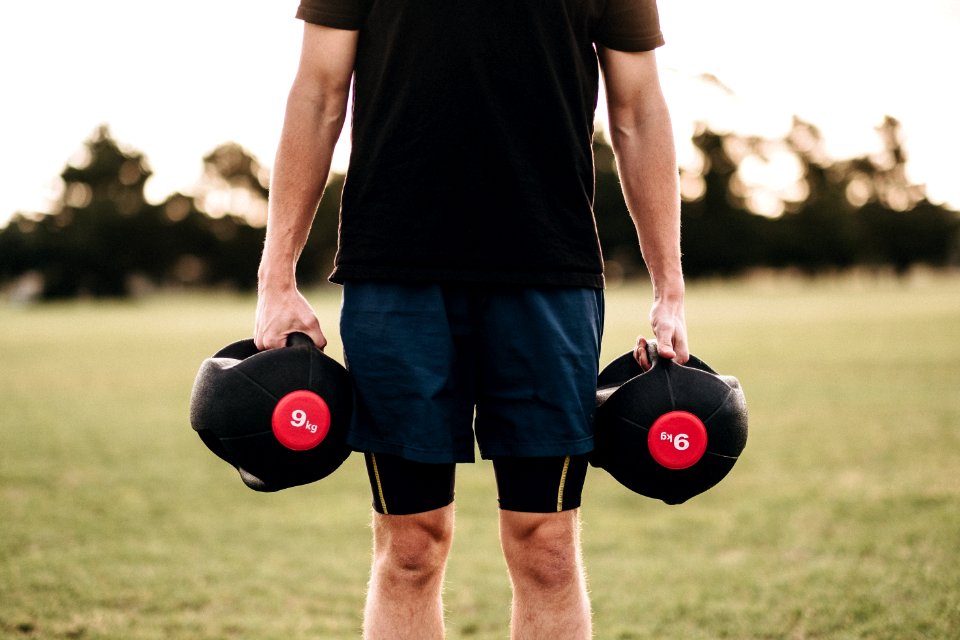 Person Holding Black Dumbbells