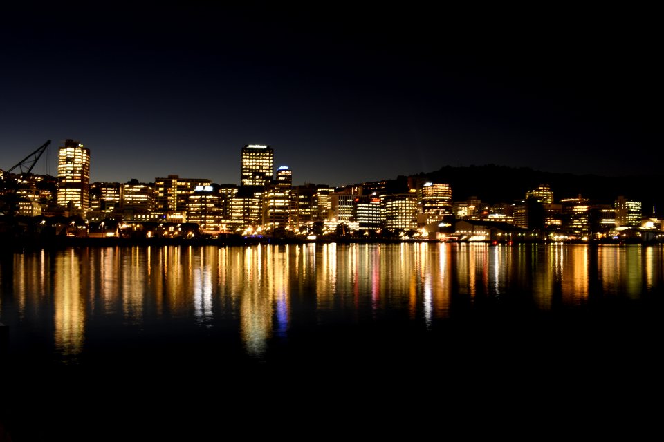 Lighted High-rise Building In Front Of Body Of Water Photo photo