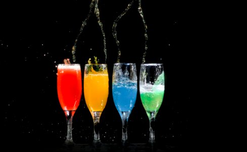 Four Champagne Flutes With Assorted-color Liquids