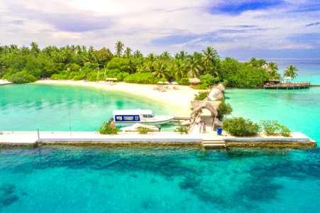 Aerial Photography Of White Dock By The Ocean Surrounded With Trees Under Blue Sky And White Clouds photo