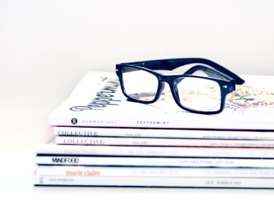Black Framed Eyeglasses On Seven Collective Books