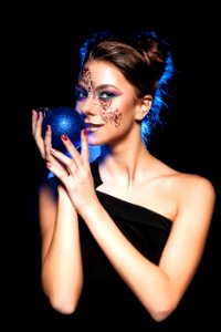 Woman Wearing Black One Shoulder Top Holding Bauble photo