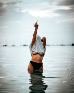 Woman Wearing White Shirt Raise His Middle Finger photo