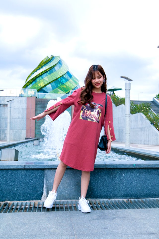 Woman Standing Beside Gray Concrete Outdoor Fountain Under Blue And White Cloudy Skies At Daytime