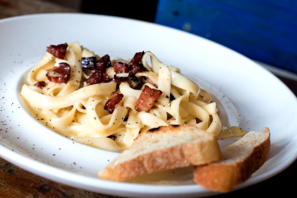 Pasta Dish With Bread On White Ceramic Plate
