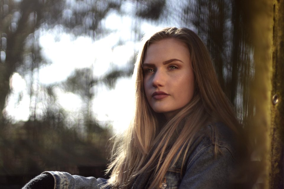 Woman Wearing Gray Denim Jacket By The Wall