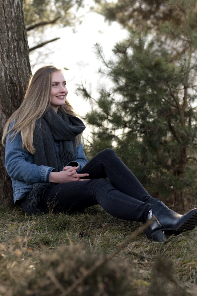 Woman Sitting On Ground Leaning Against Tree