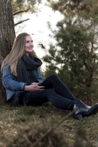 Woman Sitting On Ground Leaning Against Tree photo