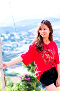 Woman Wearing Red Shirt Standing Beside A Post