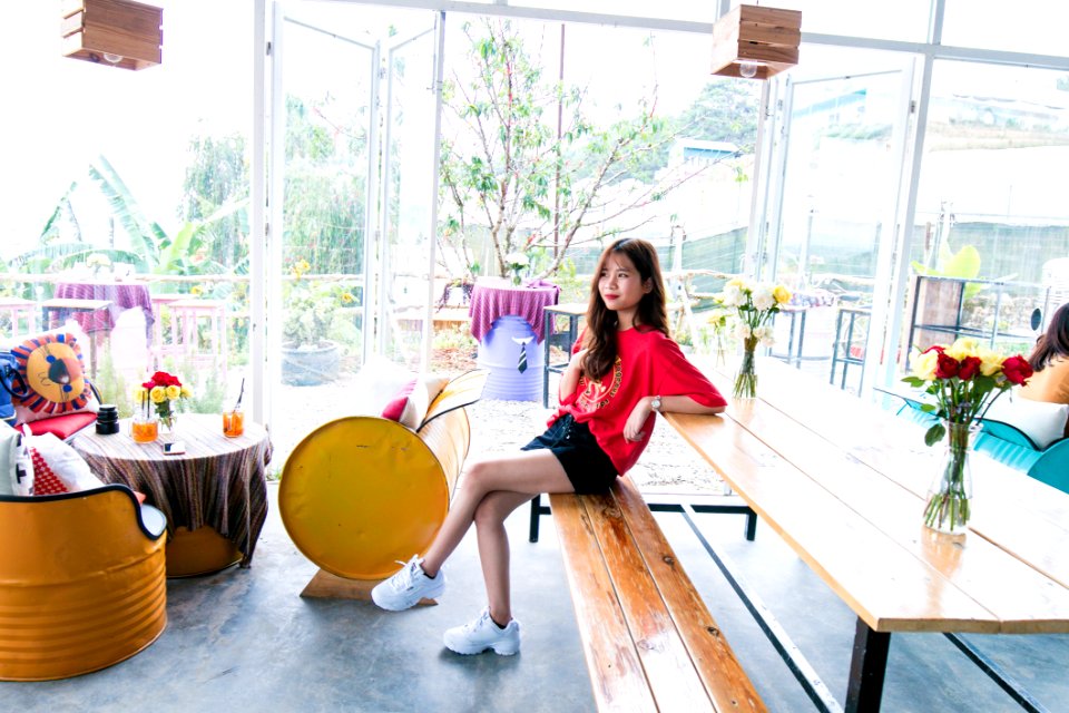 Woman In Red Crew-neck T-shirt And Blue Short Shorts Sitting On Bench