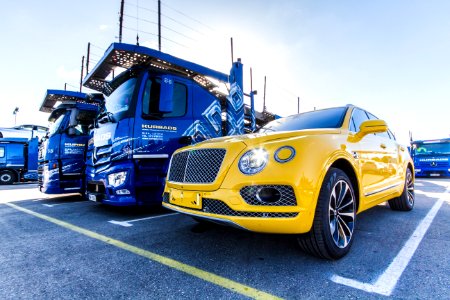 Yellow Vehicle Parked Beside Blue Truck