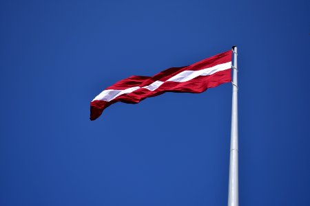 Red And White State Flag Waving Under Blue Sky At Daytime photo