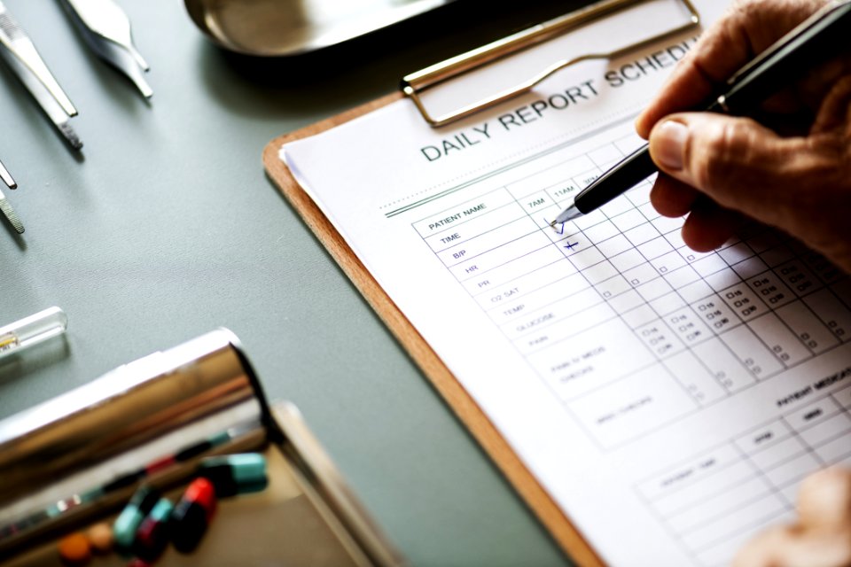 Person Filling Up The Daily Report Schedule Form