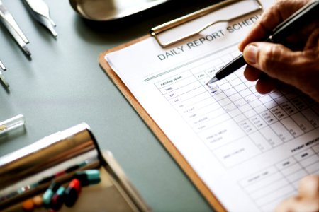 Person Filling Up The Daily Report Schedule Form
