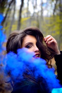 Close-Up Photography Of A Woman Near Blue Smoke