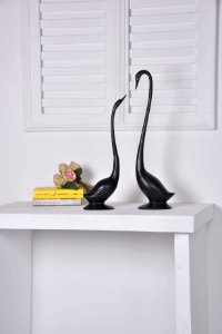Two Black Geese Figurines On White Console Table photo