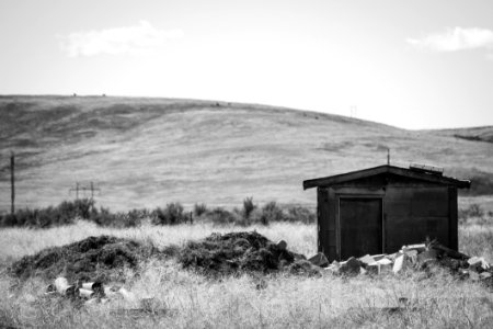 Greyscale Photography Of Brown Shed Near Mountain photo