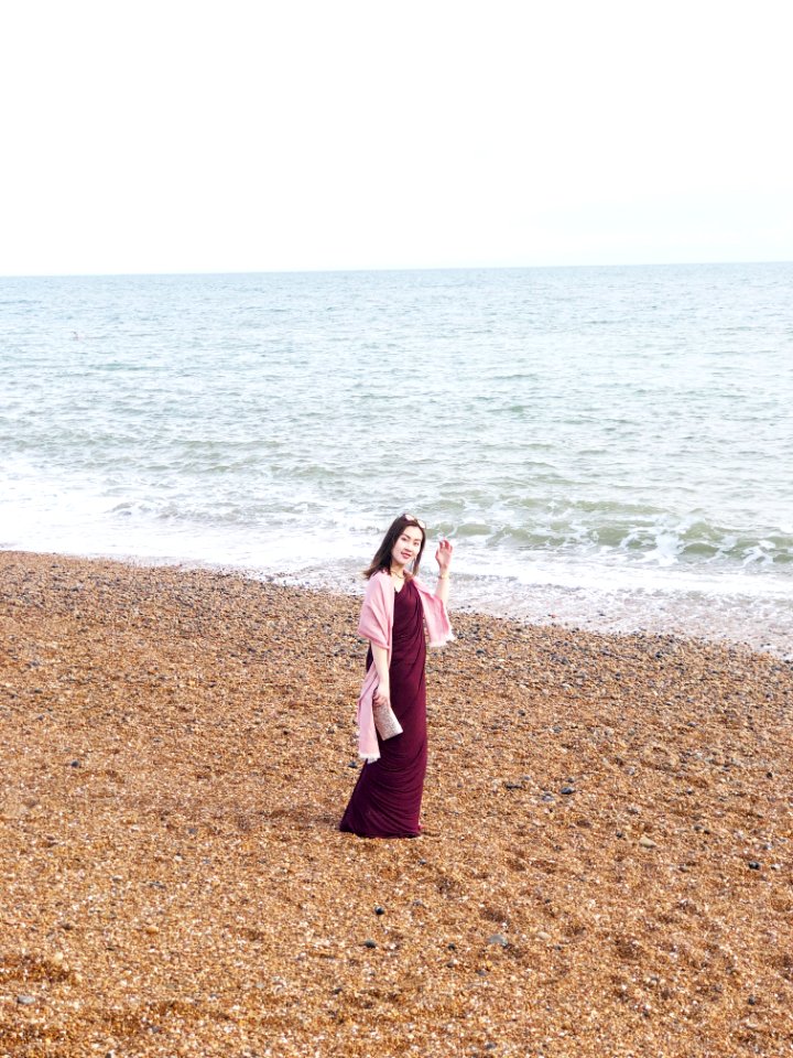 Woman Wearing Maroon Long Dress Near Seashore