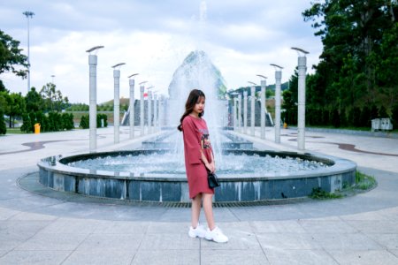 Woman Wearing Pink Crew-neck Long-sleeved Midi Dress Standing Concrete Outdoor Fountain photo