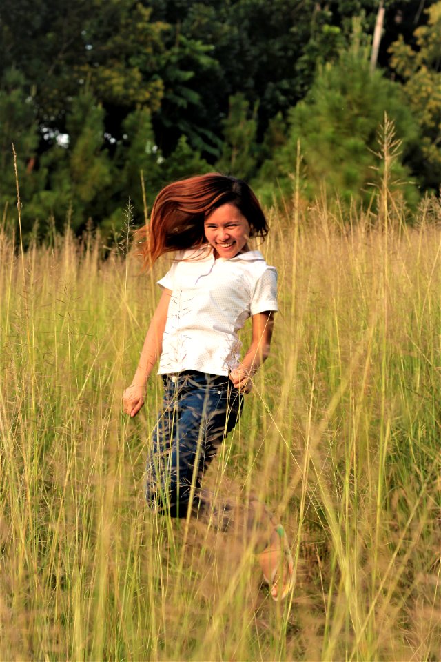 Woman Jumping Between Grass