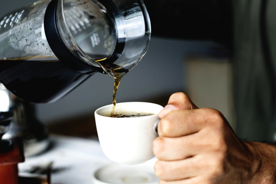Person Holding White Ceramic Cup And Glass Pitcher