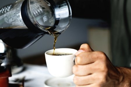 Person Holding White Ceramic Cup And Glass Pitcher photo