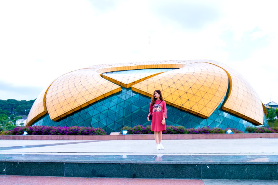 Woman Standing Near Blue And Yellow Dome Under White Cloudy Skies At Daytime