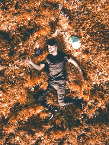 Man In Black Crew-neck Shirt And Black Pants Laying In Brown Dry Leaf photo